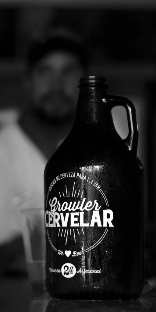 深色带手柄的Growler CERVELAR啤酒壶，表面水珠，前景突出，适合露营保温壶与户外饮料携带